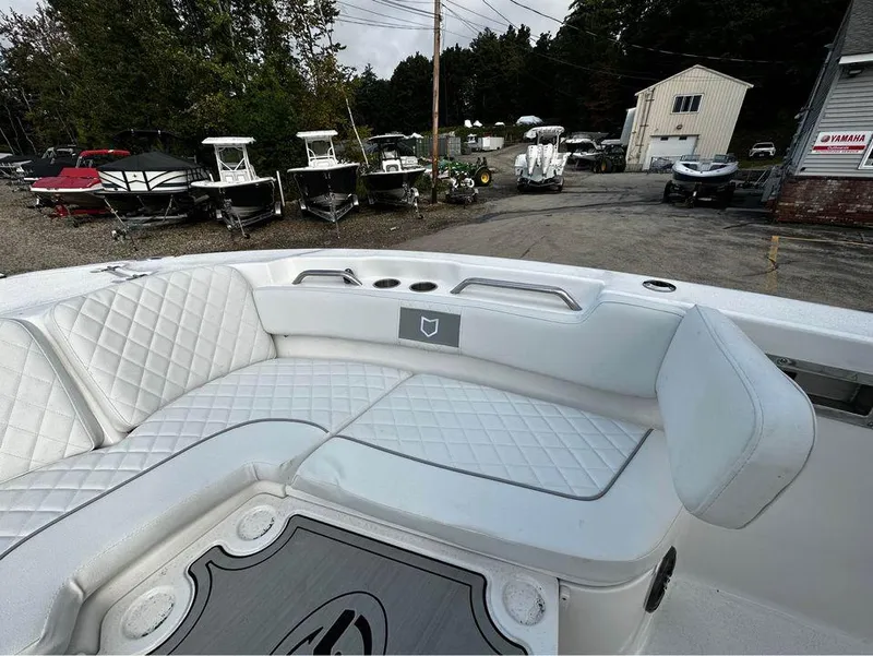 Slide: The Image of 2024 Sea Fox 248 Commander boat with white quilted seating, docked near other boats. - 4