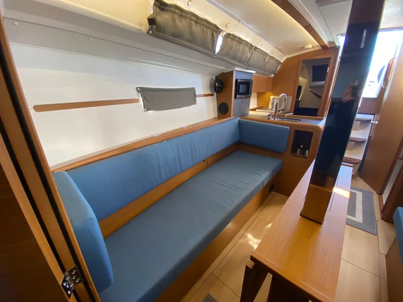 Slide: The Image of Interior of 2023 Jeanneau Sun Odyssey 349 sailboat with blue seating and modern kitchen. - 12