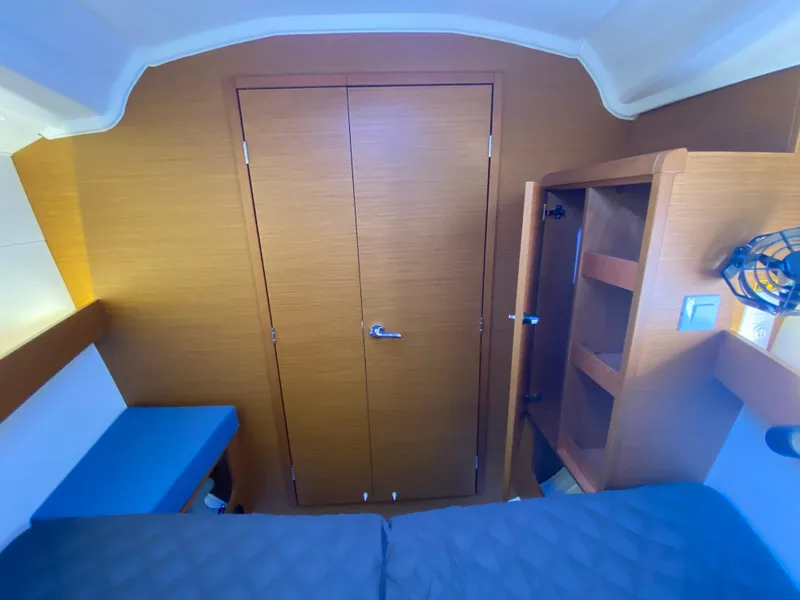 Slide: The Image of Interior cabin of 2023 Jeanneau Sun Odyssey 349 sailboat, featuring wood paneling and cozy bedding. - 17