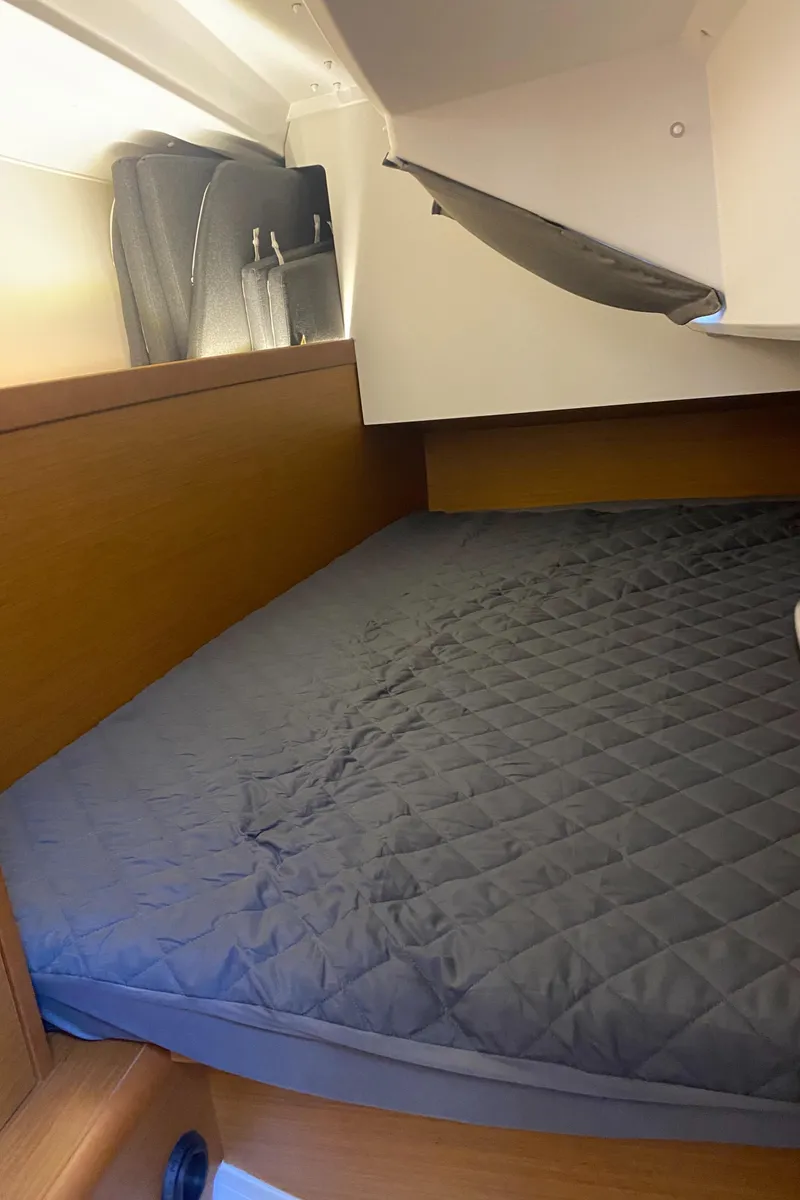 Slide: The Image of 2023 Jeanneau Sun Odyssey 349 cabin with a cozy bed and wooden interior. - 22