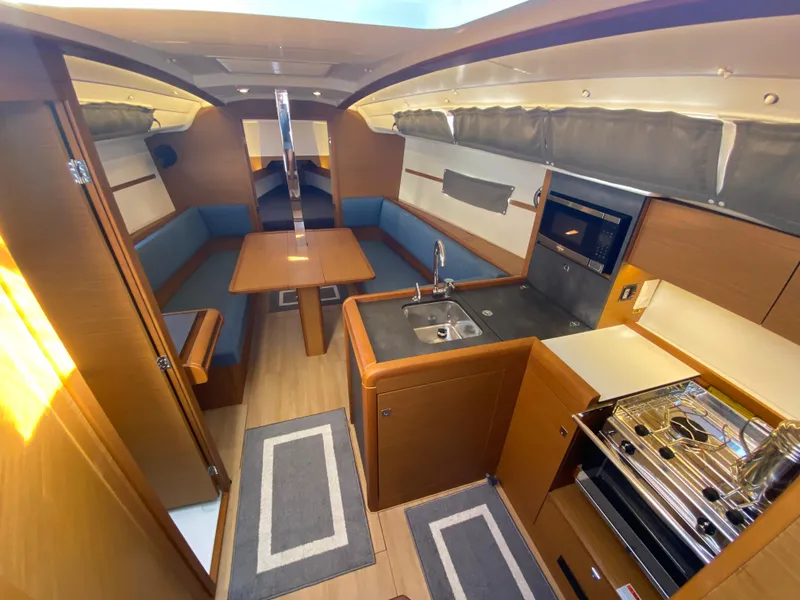 Slide: The Image of 2023 Jeanneau Sun Odyssey 349 interior with modern kitchen and cozy seating area. - 3
