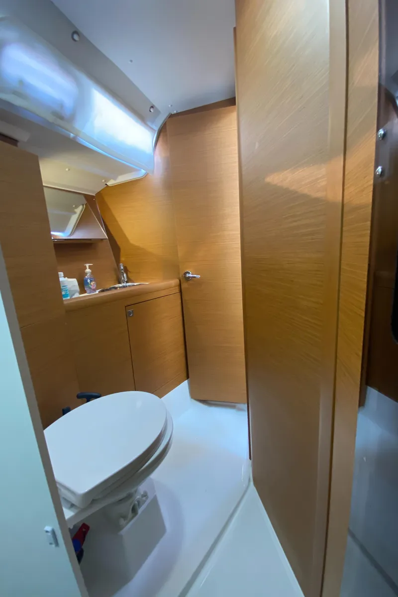Slide: The Image of 2023 Jeanneau Sun Odyssey 349 yacht bathroom with wooden cabinetry and modern fixtures. - 30