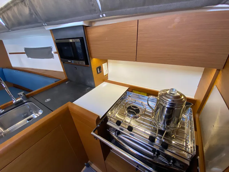 Slide: The Image of 2023 Jeanneau Sun Odyssey 349 yacht kitchen with stove, sink, and microwave. - 4