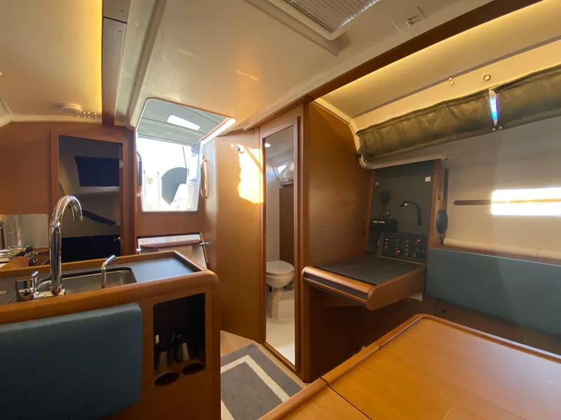 Slide: The Image of Interior of 2023 Jeanneau Sun Odyssey 349 sailboat, featuring kitchen and seating area. - 5