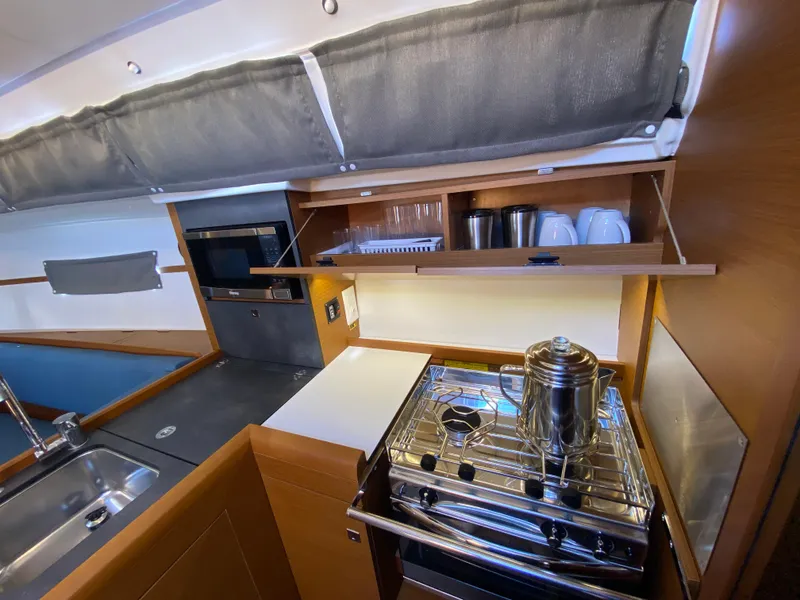 Slide: The Image of Modern kitchen interior of 2023 Jeanneau Sun Odyssey 349 yacht with stove and storage. - 7