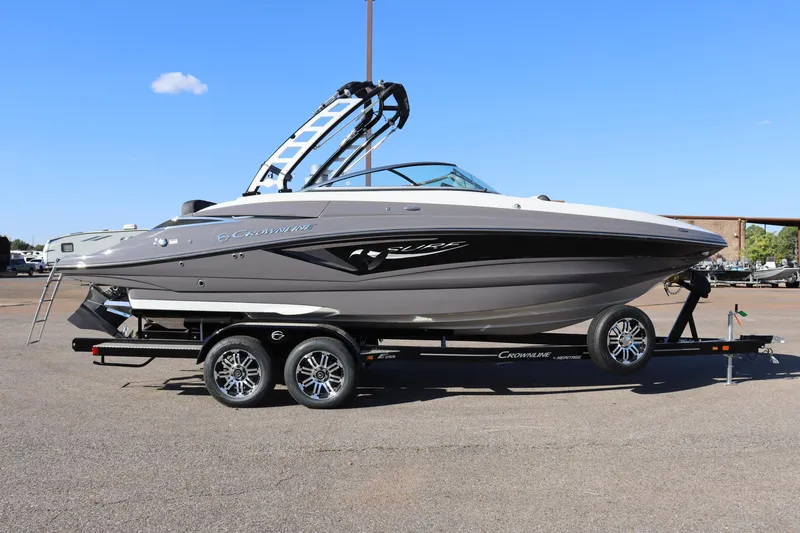 The Image of 2024 Crownline E255 Surf boat on a trailer, side view, outdoors. - 0