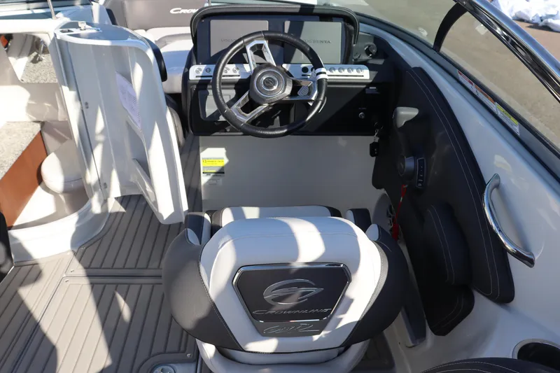 Slide: The Image of 2024 Crownline Eclipse E255 SURF boat with illuminated blue speakers in a showroom. - 10