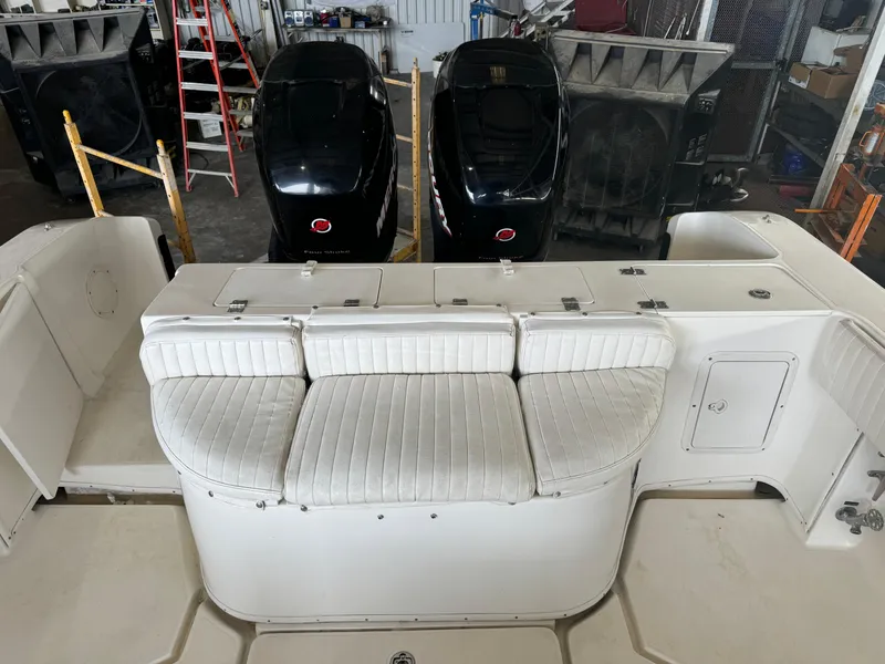 Slide: The Image of 2007 Fountain 32 CC boat interior with twin outboard motors in a workshop setting. - 10