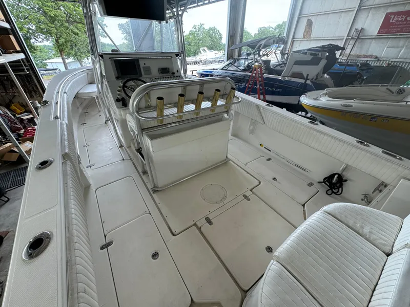 Slide: The Image of 2007 Fountain 32 CC boat interior with white seating and control panel in a storage facility. - 11