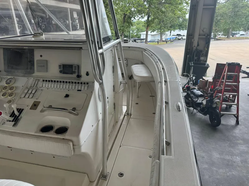 Slide: The Image of 2007 Fountain 32 CC boat interior with control panel and seating, docked in a garage. - 14