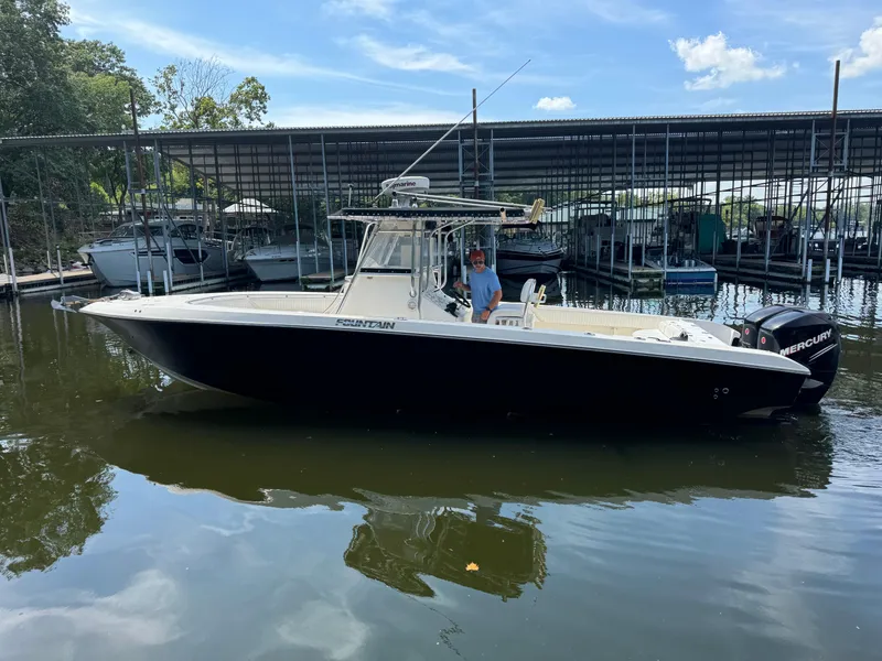 Slide: The Image of 2007 Fountain 32 CC boat docked, featuring sleek design and Mercury engines. - 3
