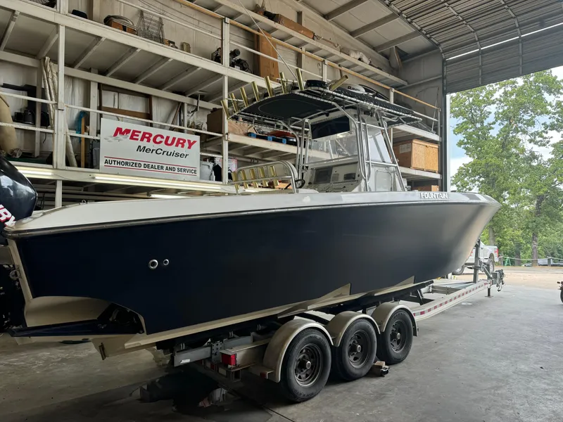 Slide: The Image of 2007 Fountain 32 CC boat on trailer in a garage, Mercury MerCruiser sign visible. - 6