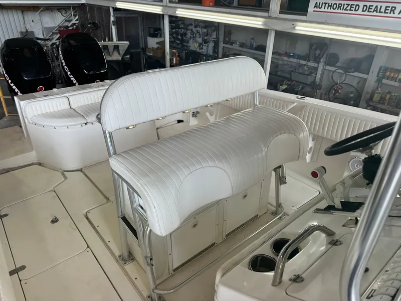 Slide: The Image of 2007 Fountain 32 CC boat interior with white seating and dual Mercury engines. - 8