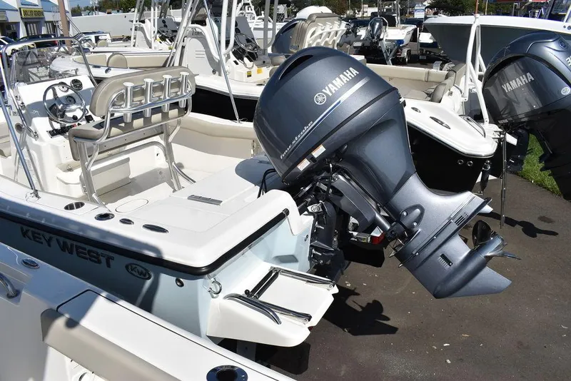 Slide: The Image of 2024 Key West 179 FS boat with Yamaha outboard motor, docked in a marina. - 7