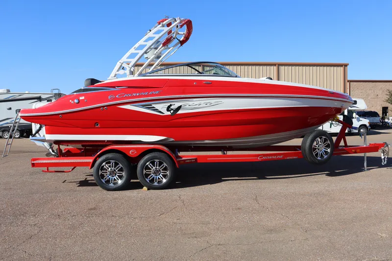 The Image of 2024 Crownline 260SS SURF boat on a red trailer. - 0