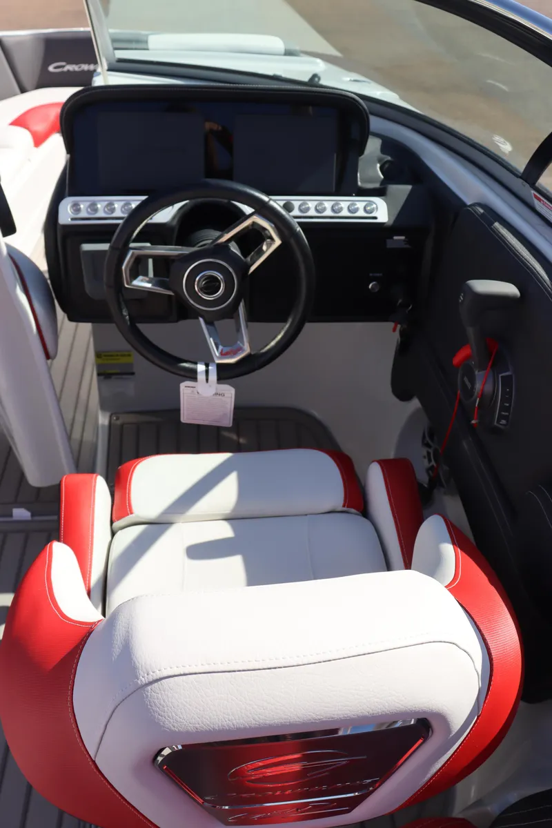 Slide: The Image of 2024 Crownline 260SS SURF boat cockpit with steering wheel and red-white seating. - 14