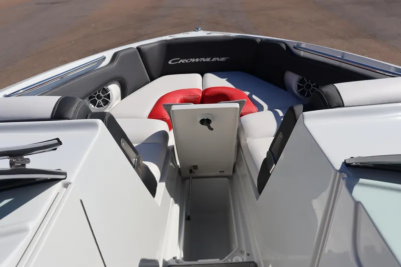 Slide: The Image of 2024 Crownline 260SS SURF boat interior with cushioned seating and storage compartment. - 18