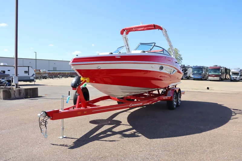 Slide: The Image of 2024 Crownline 260SS SURF boat on a red trailer in a parking lot. - 3