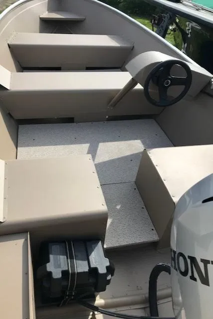 Slide: The Image of 2024 Polar Kraft Dakota 1670 boat interior with steering wheel and Honda engine. - 3