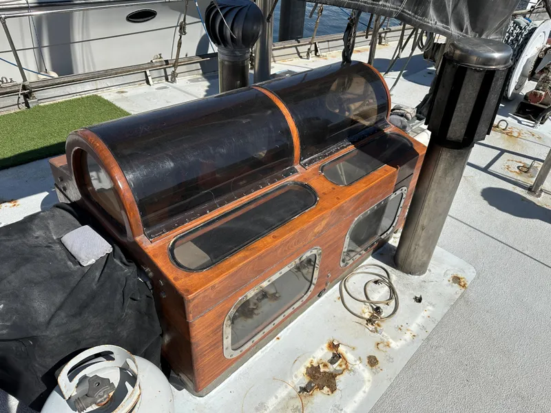 Slide: The Image of Wooden deck box on a 2000 Bruce Roberts Ketch sailboat, featuring clear panels and metal accents. - 10