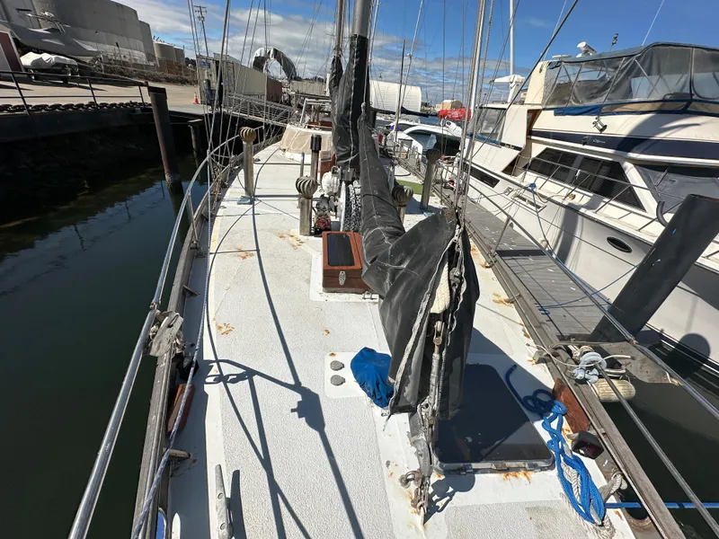 Slide: The Image of Bruce Roberts Ketch 2000 sailboat docked, featuring deck view with rigging and marina surroundings. - 14