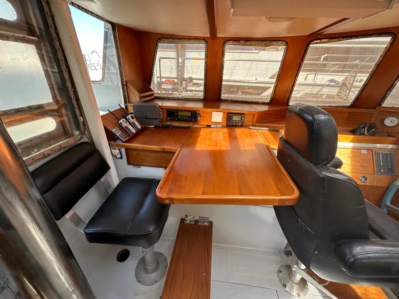 Slide: The Image of Interior of 2000 Bruce Roberts Ketch with wooden table and seating in the cabin. - 16