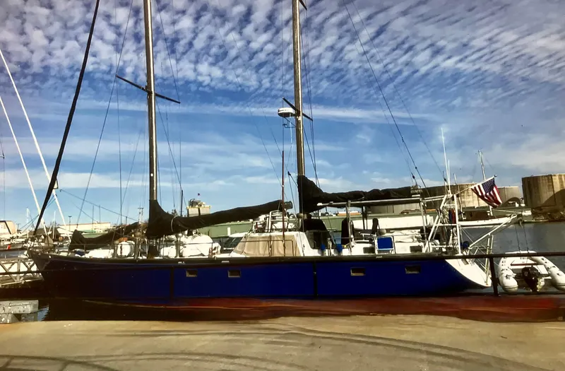 Slide: The Image of Bruce Roberts 2000 Ketch sailboat docked at marina under blue sky. - 2