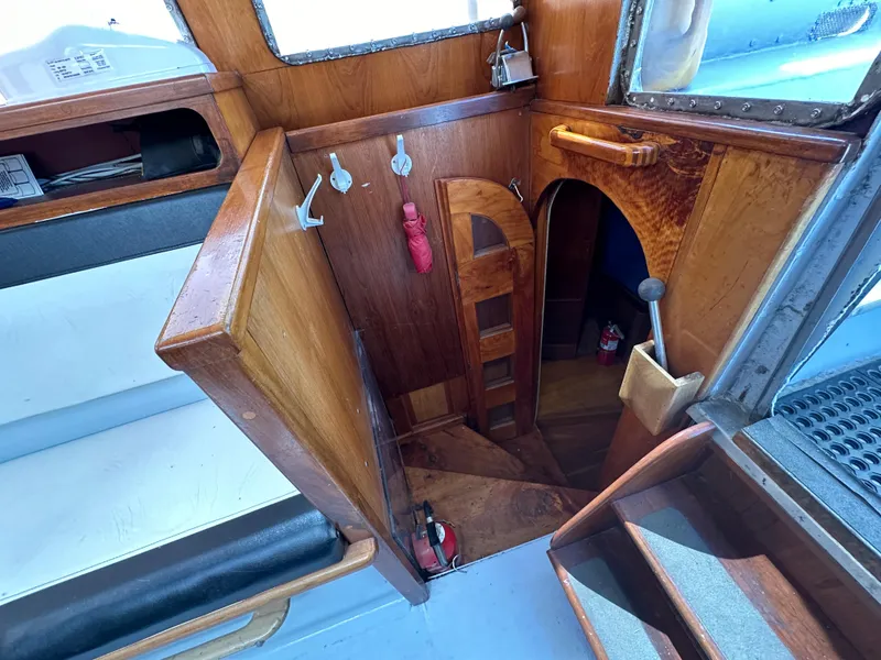Slide: The Image of Interior of a 2000 Bruce Roberts Ketch, featuring wooden stairs and nautical decor. - 20