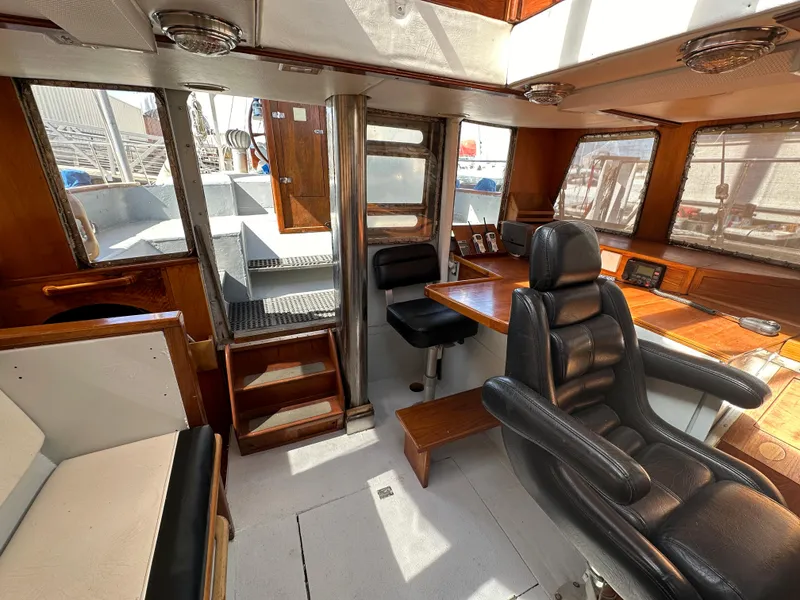 Slide: The Image of Interior of 2000 Bruce Roberts Ketch, featuring wood accents and leather seating. - 21