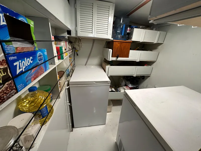 Slide: The Image of Storage room with shelves, freezer, and pantry items on a Bruce Roberts Ketch 2000. - 25