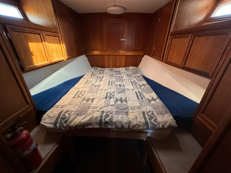 Slide: The Image of Cozy cabin interior of 2000 Bruce Roberts Ketch with wooden paneling and patterned bedding. - 36
