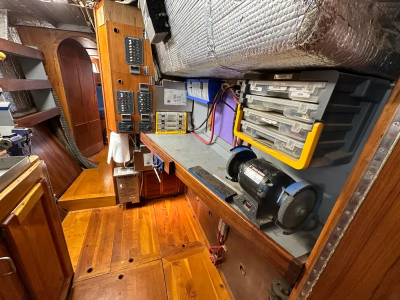 Slide: The Image of Interior of a 2000 Bruce Roberts Ketch with wooden flooring and electrical panels. - 40
