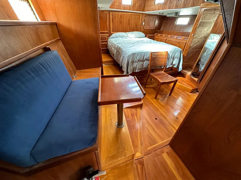 Slide: The Image of Interior of 2000 Bruce Roberts Ketch with wooden furnishings and cozy sleeping area. - 45