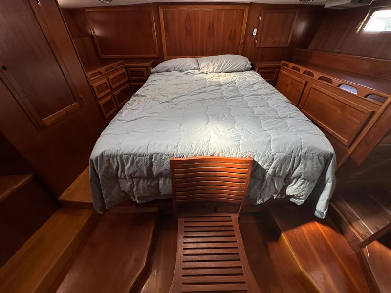 Slide: The Image of Cozy cabin interior of 2000 Bruce Roberts Ketch with wooden furnishings and a comfortable bed. - 47