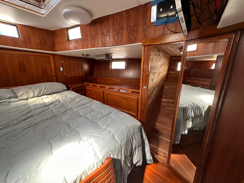 Slide: The Image of Cozy wooden interior of 2000 Bruce Roberts Ketch with bed and mirror. - 49