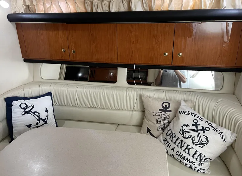 Slide: The Image of Interior of 2001 Sea Ray 340 Sundancer with nautical-themed cushions and wooden cabinets. - 12