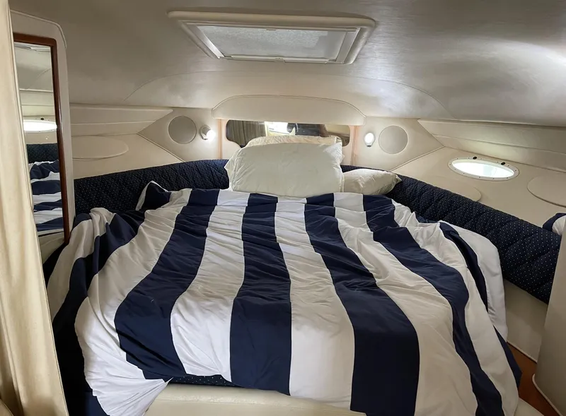 Slide: The Image of Cozy cabin interior of 2001 Sea Ray 340 Sundancer with striped bedding. - 14