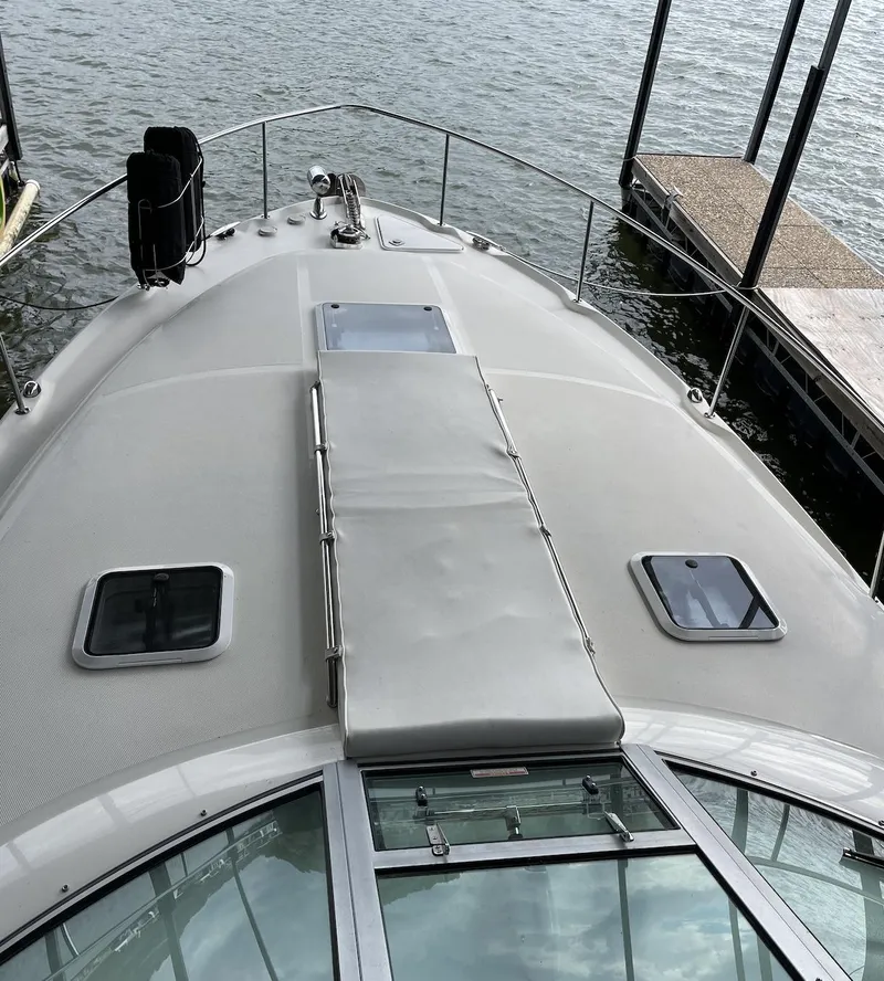 Slide: The Image of 2001 Sea Ray 340 Sundancer boat deck with hatches, docked on calm water. - 6