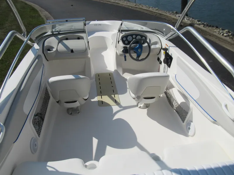 Slide: The Image of 2006 Glastron MX 195 boat interior with dual seats and steering wheel, dockside view. - 11