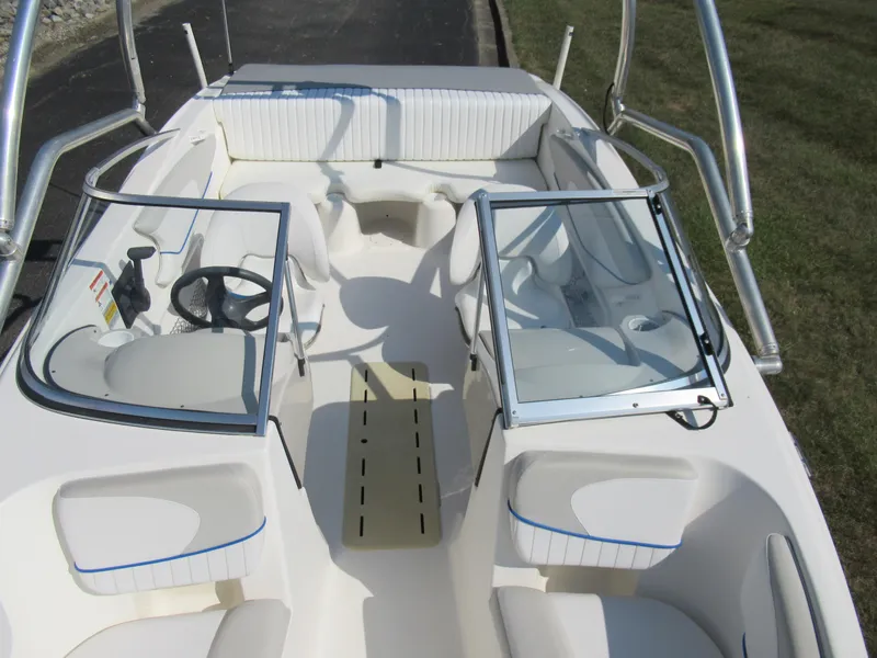 Slide: The Image of 2006 Glastron MX 195 boat interior with seating and steering wheel, featuring open windshield. - 21