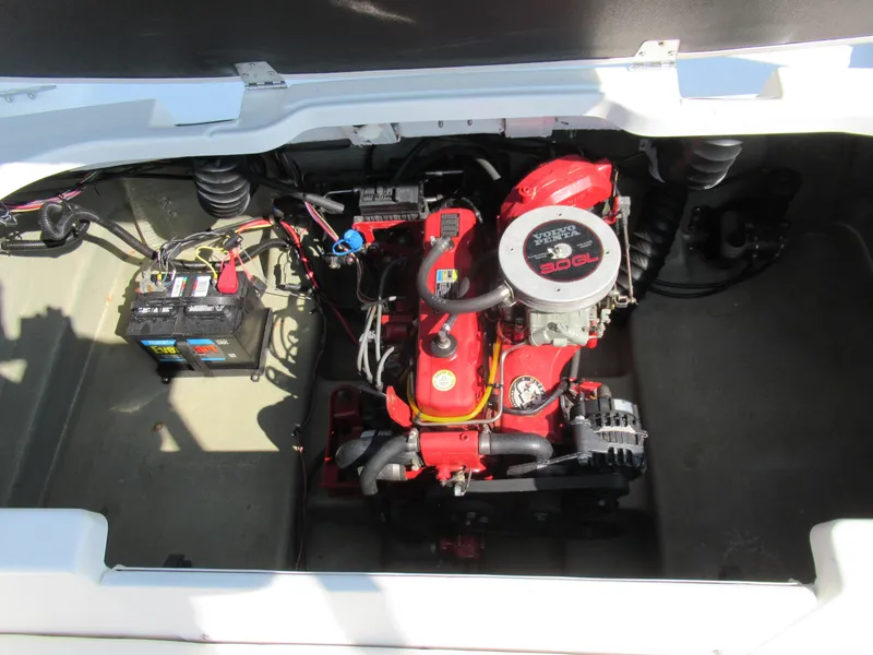 Slide: The Image of 2006 Glastron MX 195 boat engine compartment with visible battery and red engine components. - 24