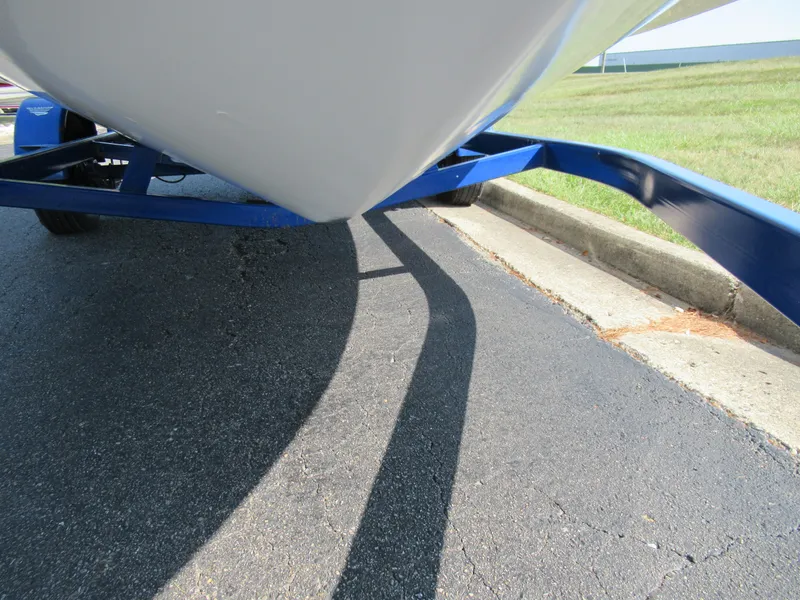 Slide: The Image of 2006 Glastron MX 195 boat on blue trailer, parked on asphalt near grass. - 8