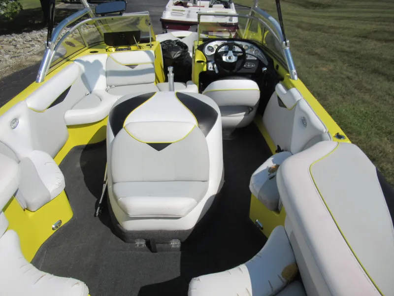 Slide: The Image of 2006 Tigé 22i boat interior with yellow and white seating, steering wheel, and dashboard. - 10