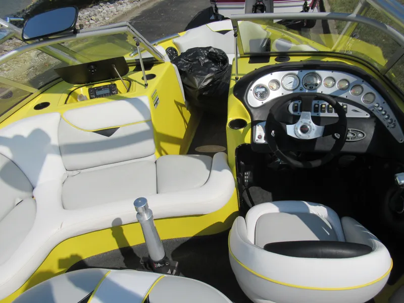 Slide: The Image of 2006 Tigé 22i boat interior with yellow and white seating, modern dashboard, and steering wheel. - 12