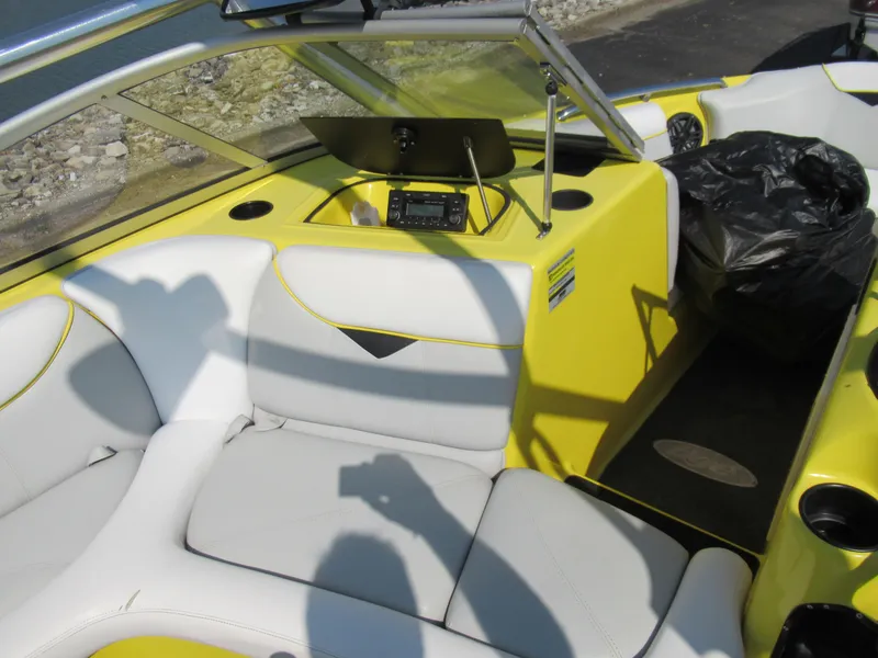 Slide: The Image of 2006 Tigé 22i boat interior with yellow and white seating, dashboard, and windshield. - 14