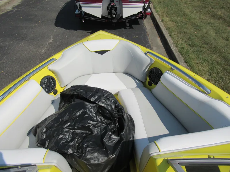 Slide: The Image of 2006 Tigé 22i boat interior with yellow and white seating, black bag on seats. - 16