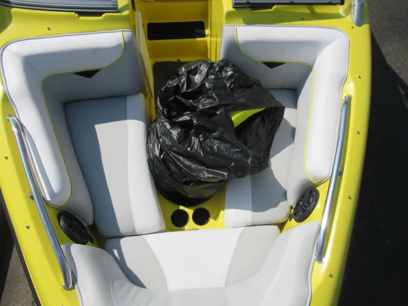 Slide: The Image of 2006 Tigé 22i boat interior with yellow and white seating, black bag in center. - 18