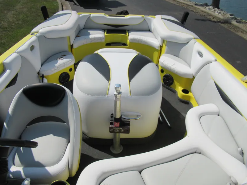 Slide: The Image of 2006 Tigé 22i boat interior with white and yellow seating, near water. - 20