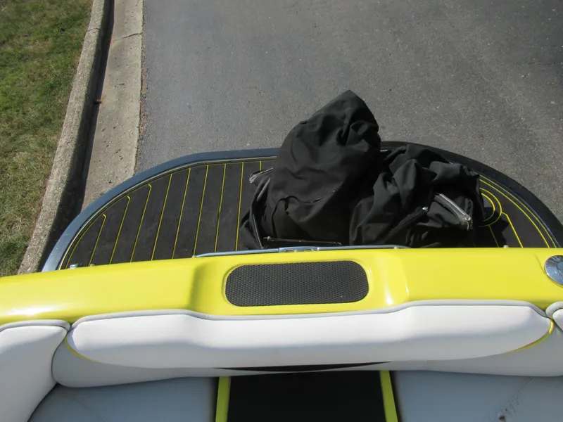 Slide: The Image of 2006 Tigé 22i boat with yellow and white seating, black bag on deck. - 23