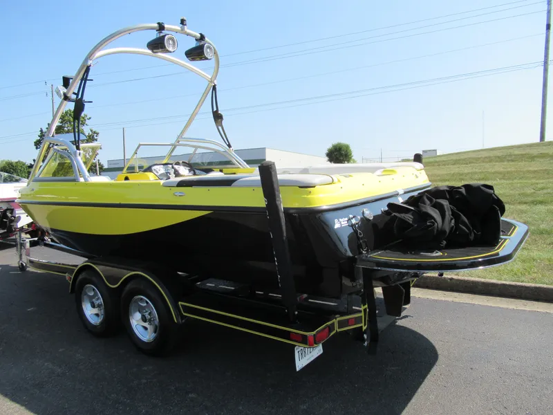 Slide: The Image of 2006 Tigé 22i boat with yellow and black design on a trailer. - 3